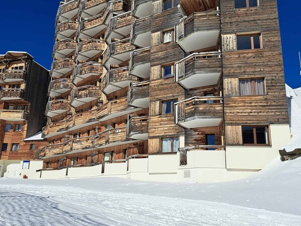 Un hotel a più piani con facciata in legno e balconi.
