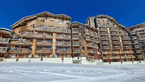 En flerlags bygning i træ med balkoner, sandsynligvis et hotel eller resort.