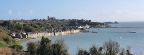 A coastal town with a prominent church, a marina, and residential buildings along the waterfront. - Cancale - Côte D'émeraude (Cancale)