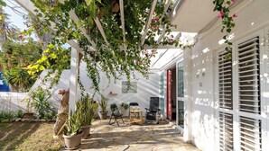 A covered patio with stone flooring, potted plants, and outdoor furniture. - Blossom Holiday Villa DPS18 (Paralimni)