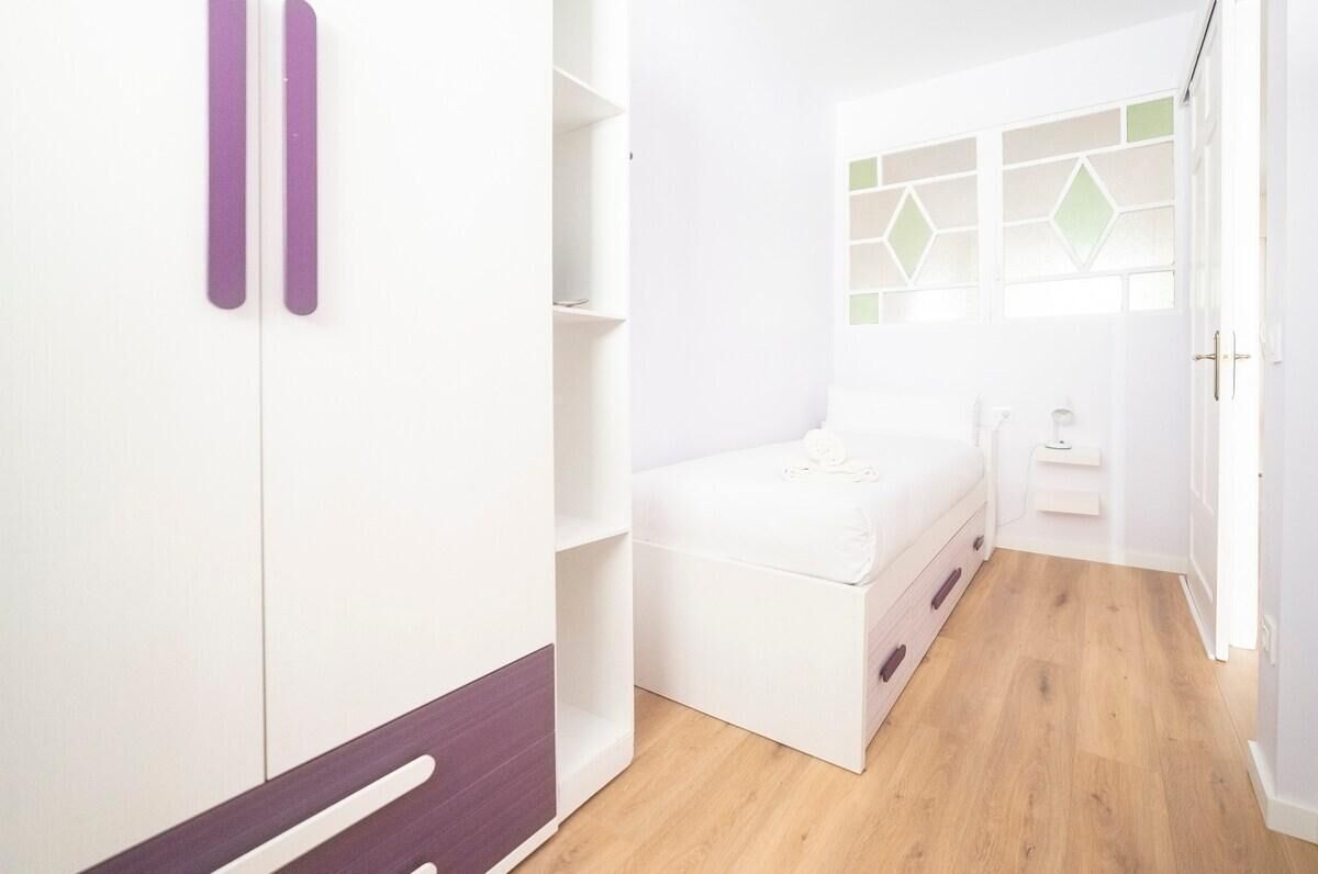 Une chambre à coucher avec un lit, une armoire et un petit bureau.