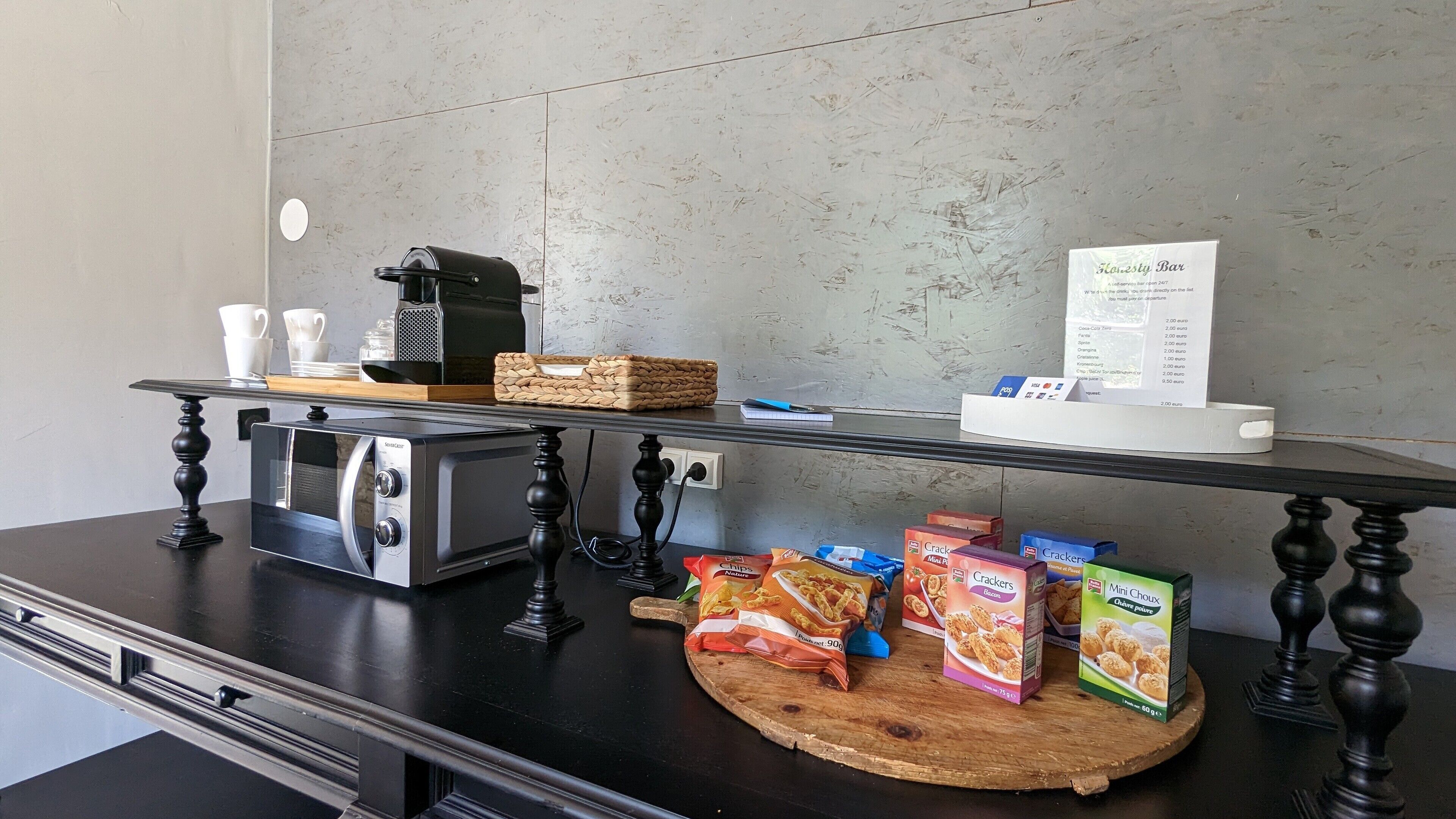 A kitchenette area with a coffee maker, a menu board, and snack boxes.