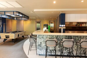 Una cocina moderna con barra, mesa de billar y zona de estar.