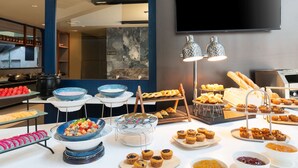 Un buffet proposant une variété de plats et un téléviseur fixé au mur.