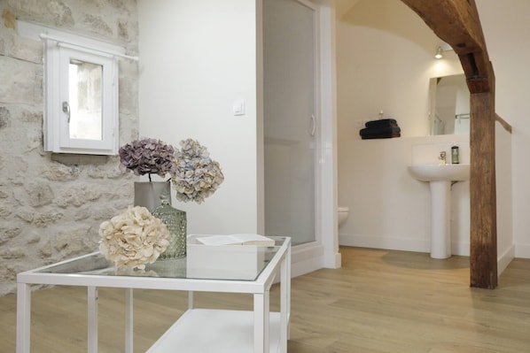 A bathroom with a white sink, a mirror, and a shower.