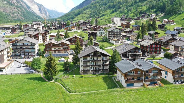A mountain village with traditional chalet-style buildings, a central square, and a view of the surrounding mountains. - Comfortable Studio Your Home Near Zermatt (Taesch)