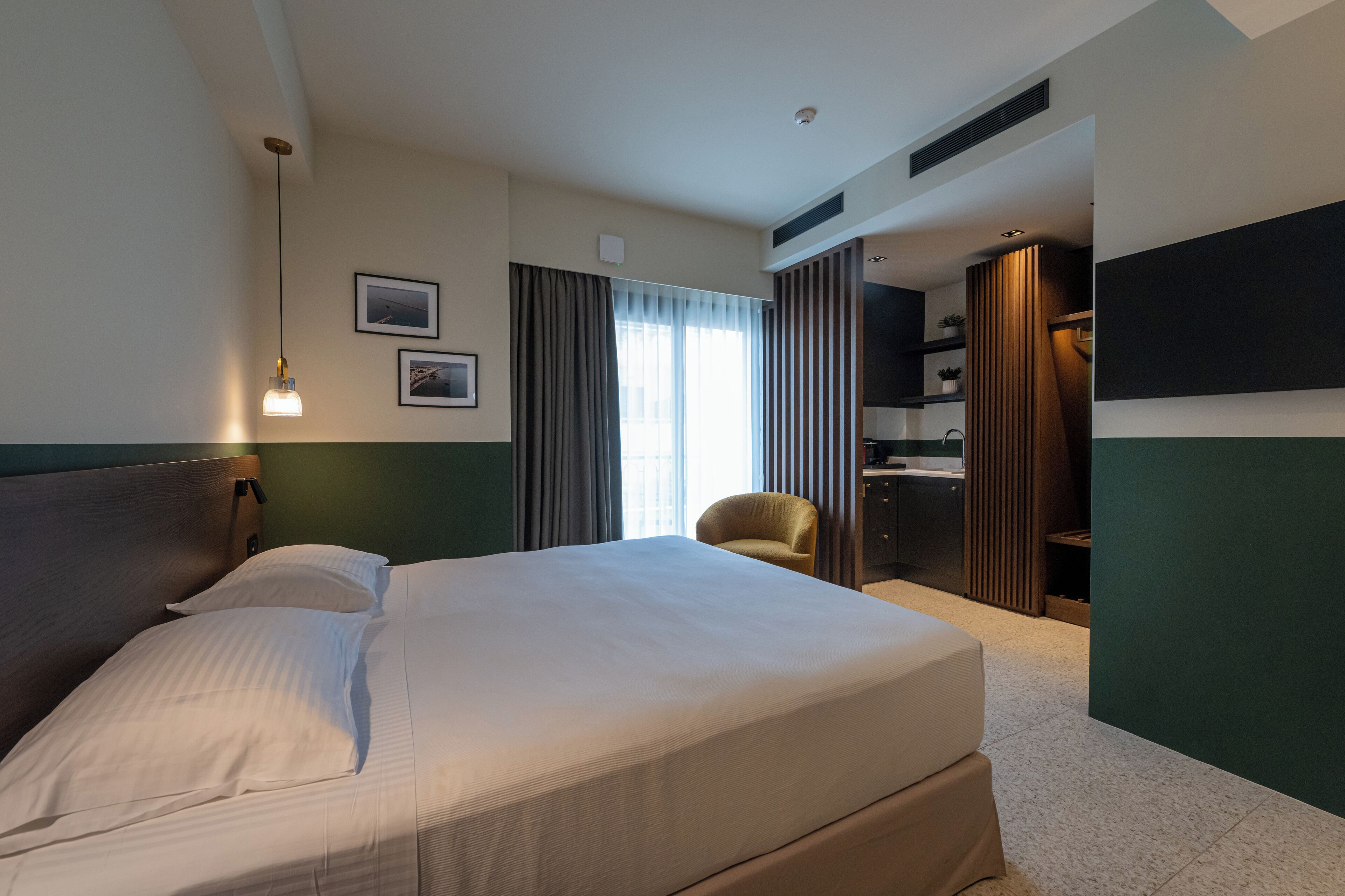 Une chambre d’hôtel avec un grand lit, une chaise, un bureau et un miroir.