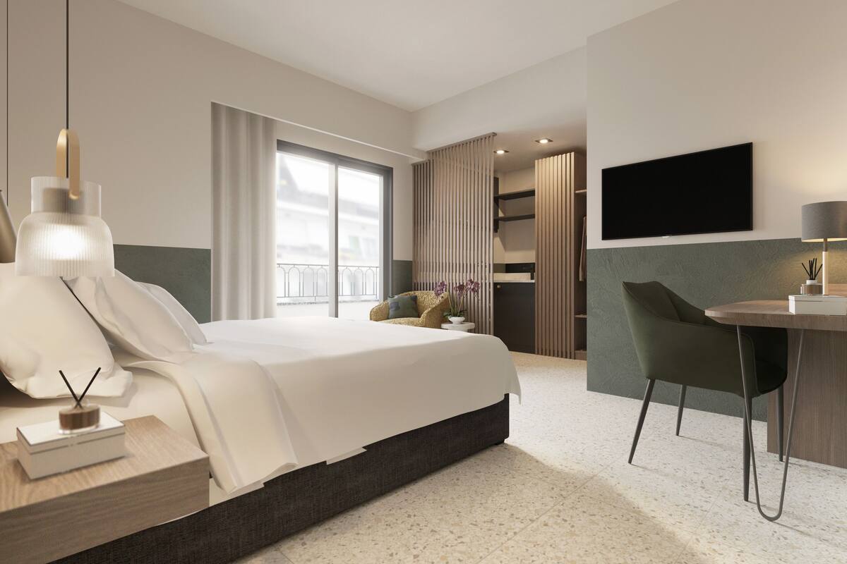 Ein modernes Hotelzimmer mit einem großen Bett, einem Schreibtisch, einem Stuhl, einem Fernseher und einem Balkon mit Blick.