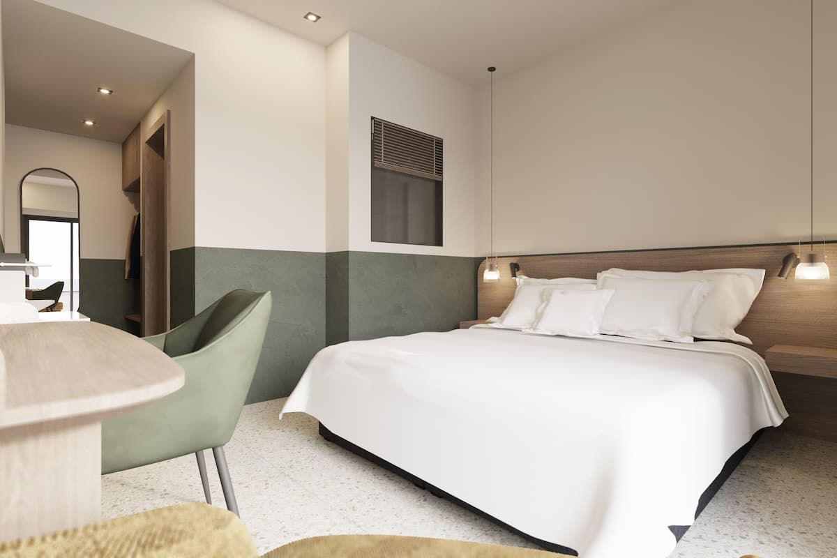 Ein modernes Hotelzimmer mit einem großen Bett, einem Sessel, einem Schreibtisch und einem Spiegel.