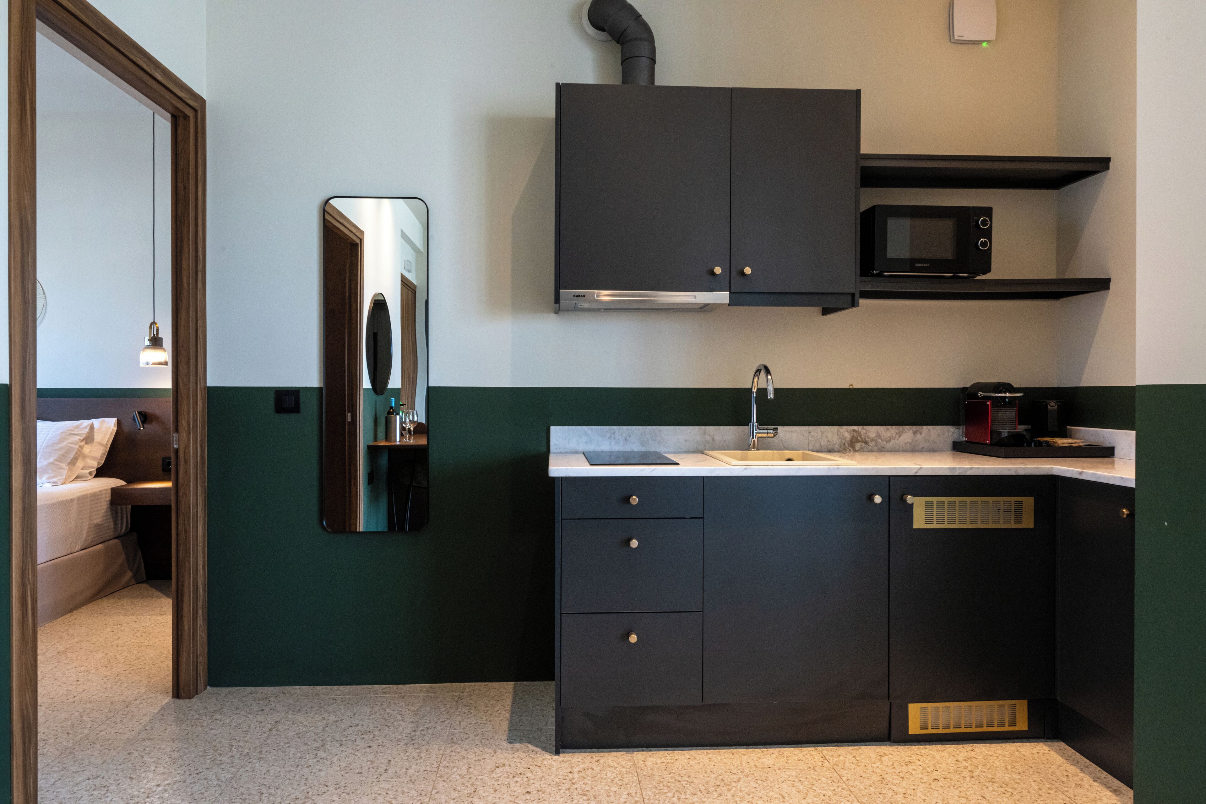 A compact kitchen with dark cabinets, a microwave, and a sink.