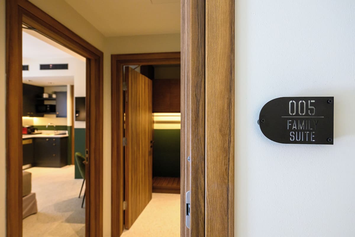Ein Flur, der zu einer Familien Suite führt, mit einem Schild, auf dem die Zimmernummer 005 angegeben ist.