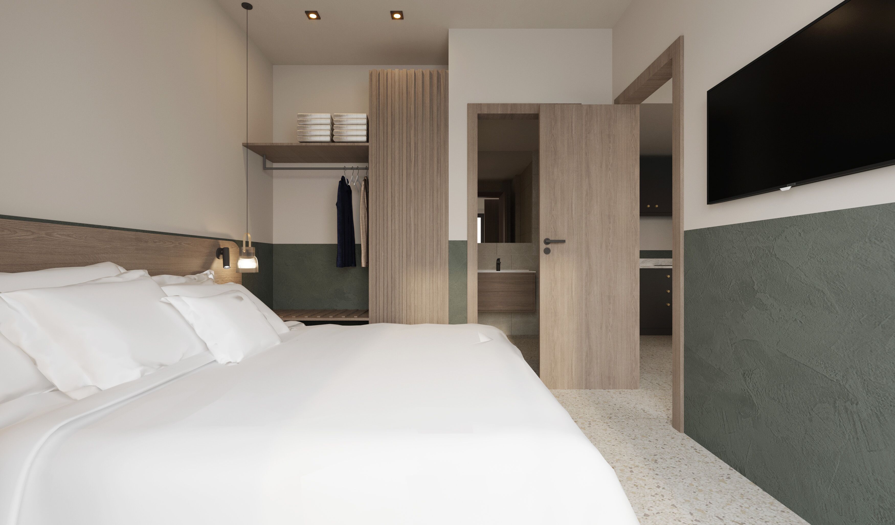 Ein modernes Hotelzimmer mit einem großen Bett, einem an der Wand montierten Fernseher, einem Badezimmer mit Spiegel und einer kleinen Küchenzeile.