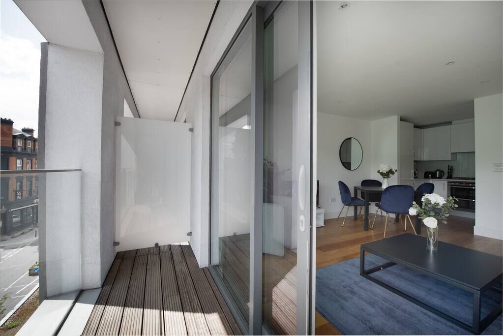 A modern apartment with a balcony, a dining area, and a kitchen.