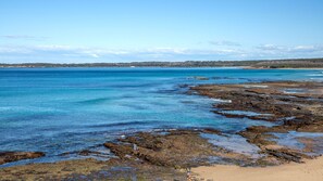 A coastal landscape with clear blue waters, rocky shorelines, and distant landforms. - Beachway - Pet Friendly - 2 Mins Walk to Beach (Berrara)
