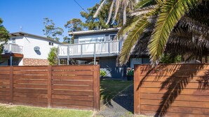 A residential property with a fenced backyard, a balcony, and a satellite dish.