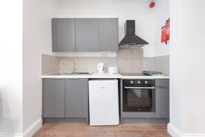 Een oven, een kookplaat, een broodrooster, kookgerei, borden en bestek