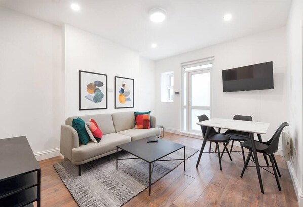 Una sala moderna con sofá, mesa de centro y comedor.