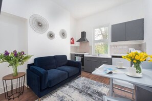 Cozy living space with a sofa, dining area, and kitchen, perfect for small stays.