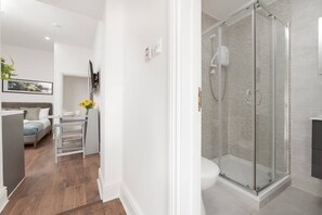 Une salle de bain moderne avec une douche à parois de verre, des toilettes et un lavabo.