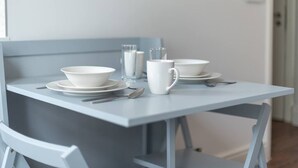 A dining table set with white dishes, a cup, and cutlery. - PBC | Large Studio - Earl's Court 119 - EC6 (London)