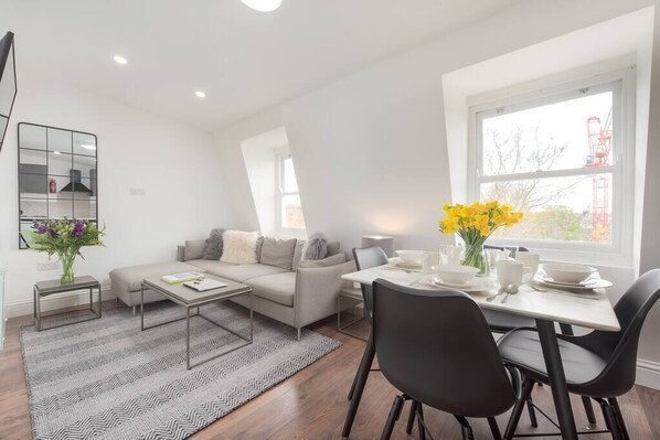 Relax in this stylish living room with a sofa set, coffee table, and dining area.