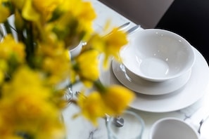 A beautifully set dining table features a bouquet of flowers and fine china.