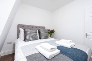 Relax in a stylishly designed room with a large bed, tufted headboard, and plush pillows.