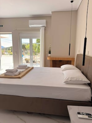 Une chambre d’hôtel comprenant un lit, une table de chevet avec une télécommande, une fenêtre donnant sur l’extérieur et un climatiseur fixé au mur.