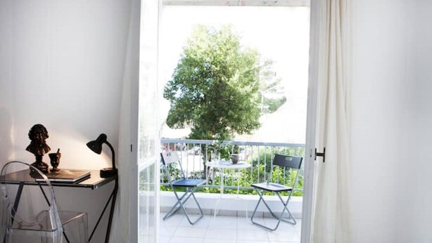 A balcony with a table, chairs, and a view of greenery. - Best Located Executive Apartment in Maroussi
 (Marousi)