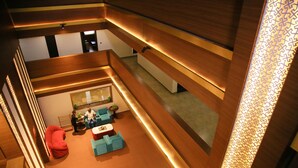 A modern interior with a seating area, a staircase, and a patterned wall. - Tiger Trails Thekkady (Peermade)