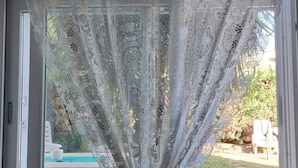 Ein Fenster mit einem weißen Spitzenvorhang.