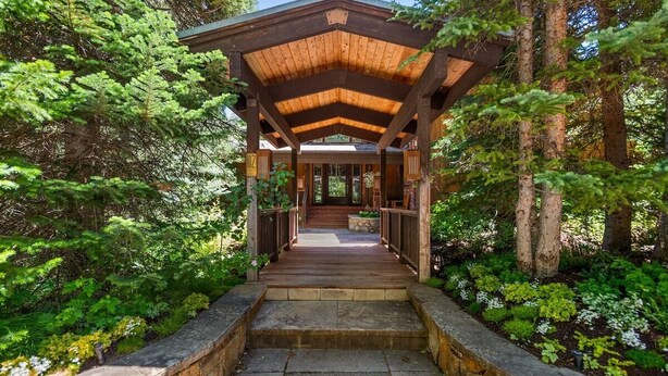 A wooden covered walkway leading to a building surrounded by dense forest. - Ski-In/Ski-Out Snowmass Estate with Hot Tub, Fireplaces & Expansive Mountain Views (Snowmass Village)