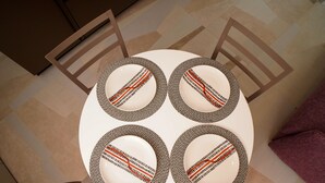A round table with four chairs, each with a patterned table runner and a central design. - The Pearl of Bari (Bari)