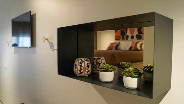 A modern room with a built-in shelf displaying decorative vases and potted plants. - The Pearl of Bari (Bari)