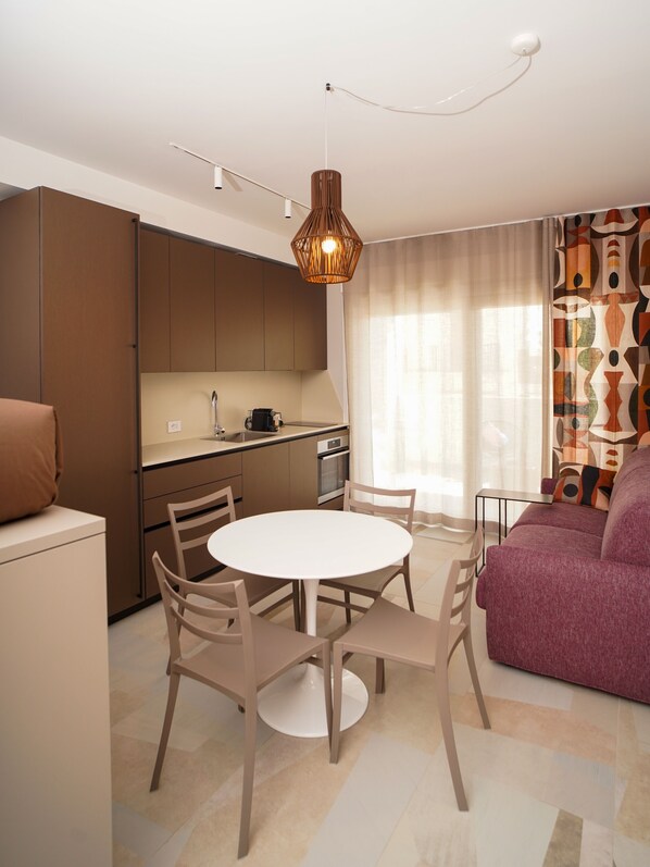 Een modern appartement met keuken, eethoek en woonkamer.
