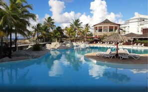 Ein Resort-Pool mit Liegestühlen und Palmen.