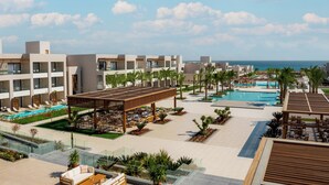 Un complexe hôtelier comprenant plusieurs bâtiments, une grande piscine et offrant une vue sur l’océan.