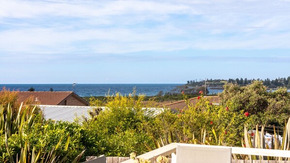 A coastal view with houses, a clear sky, and the sea in the background.