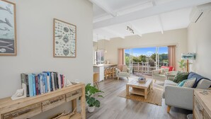Un ampio soggiorno con un tavolino in legno, un divano e una libreria piena di libri.