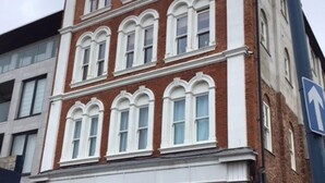 A multi-story building with a brick facade and white-framed windows. - Central Teignmouth - Sleeps 4 - Pets Allowed (Teignmouth)