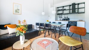 Uma sala moderna com sofá, mesa de centro e canto de jantar com cadeiras e mesa.