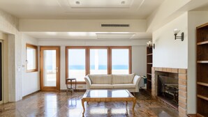 A spacious living room with a large window, a fireplace, and a sofa. - MAMAD Coastal Mansion Private Pool in Netanya by FeelHome (Netanya)