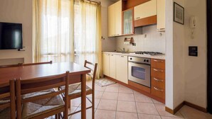 A compact kitchen with a dining table and chairs, a stove, oven, and a small countertop.