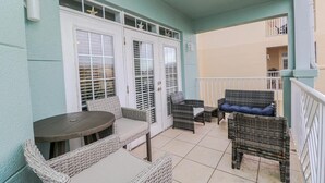 Un balcone con mobili in vimini, un tavolo e una porta decorata con stelle.