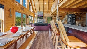 Un interior de madera con zona de comedor, chimenea de piedra y cabina telefónica.