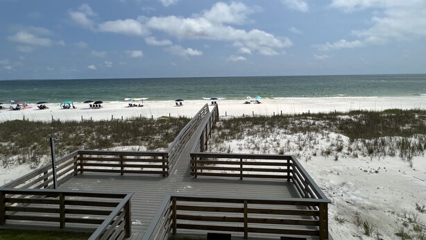 A wooden boardwalk leading to a beach with white sand and a clear blue sky. - Wake Up to 1 Beautiful Vue - Beautiful Beachfront Condo! (Mexico Beach)