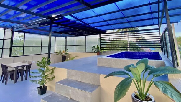 Un espacio al aire libre cubierto con piscina, asientos y escalones que conducen a un nivel superior.