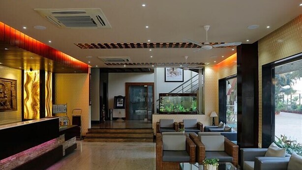 A hotel lobby with a reception desk, seating area, and a large window with a view.