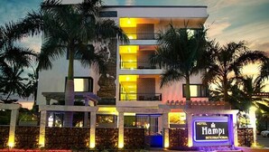 A multi-story hotel with a modern design, featuring balconies and a well-lit entrance.