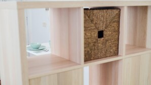 A wooden cabinet with multiple compartments, including a section with a textured door.